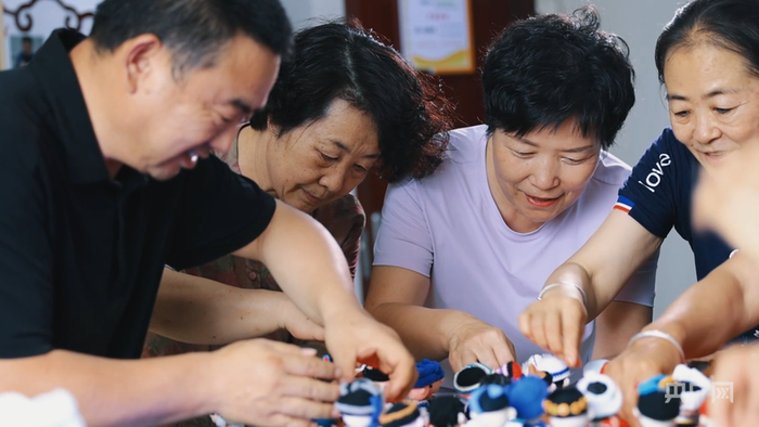 徐井飞和各族学员制作56个民族人物形象的作品 （央广网记者 姜茸 摄）
